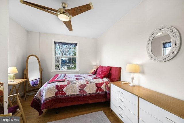 bedroom with ceiling fan, dark wood-type flooring, and vaulted ceiling