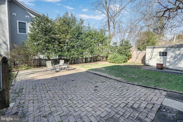 view of patio / terrace featuring an outbuilding, a fenced backyard, and a shed