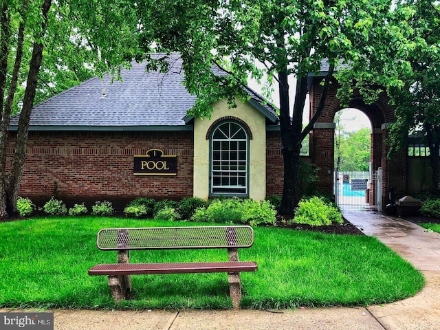 exterior space with a shingled roof and brick siding