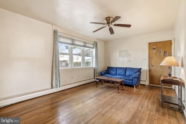 living area with a baseboard heating unit, a baseboard radiator, ceiling fan, and hardwood / wood-style flooring