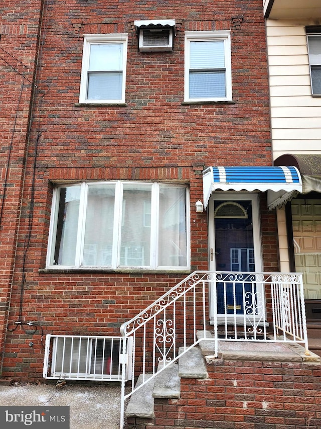 view of exterior entry with brick siding