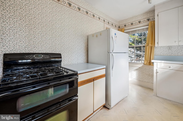 kitchen with light floors, light countertops, freestanding refrigerator, white cabinets, and double oven range