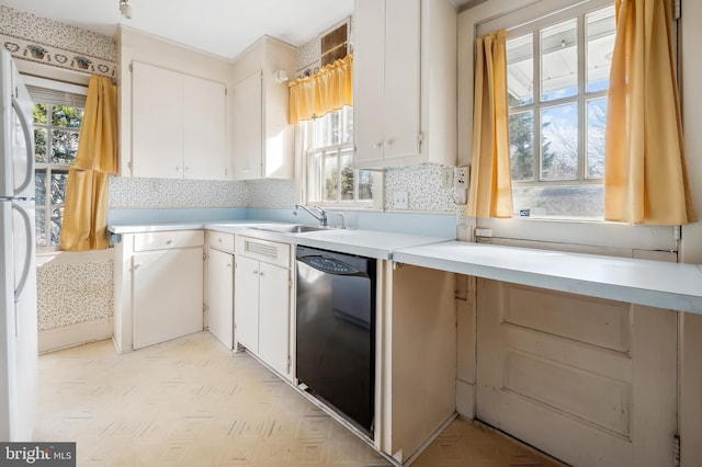 kitchen featuring light countertops, white cabinets, a sink, plenty of natural light, and dishwasher