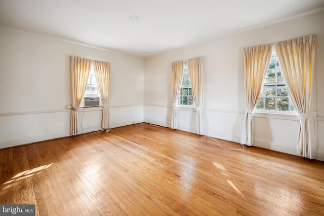 spare room with light wood finished floors and cooling unit