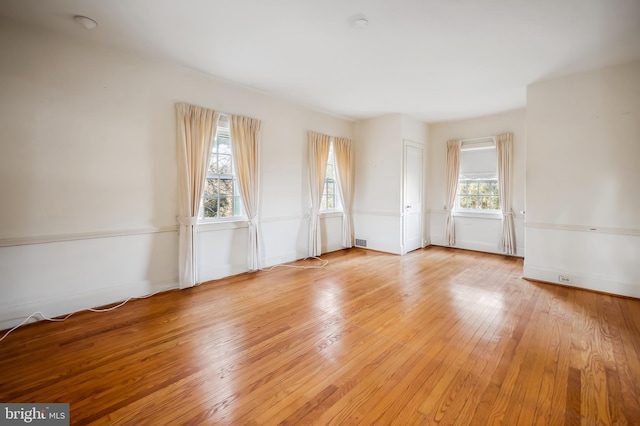 unfurnished room featuring light wood finished floors and visible vents