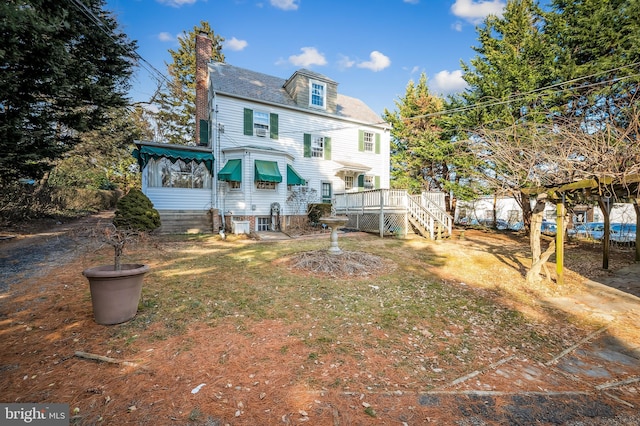 rear view of house featuring a chimney and a wooden deck