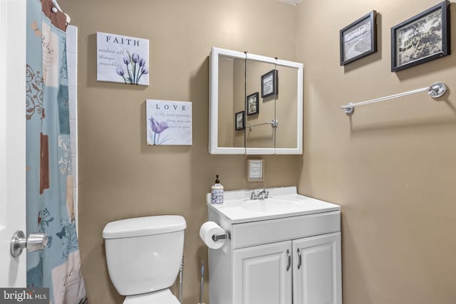 bathroom featuring vanity, toilet, and a shower with shower curtain