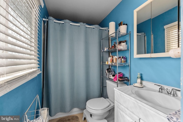 bathroom featuring a shower with curtain, vanity, and toilet