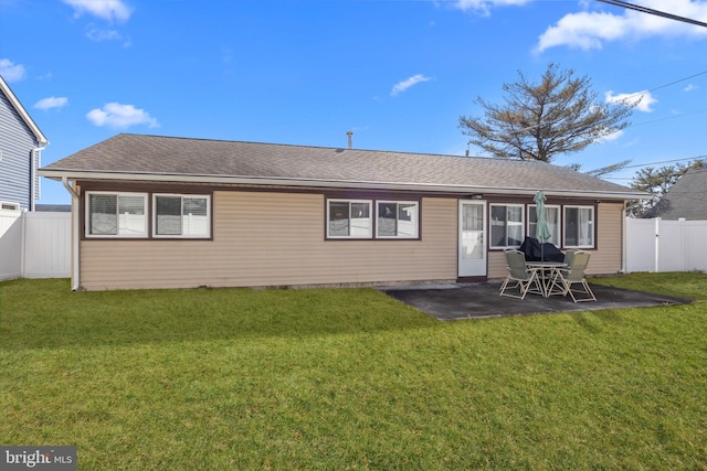 back of property with a yard and a patio area