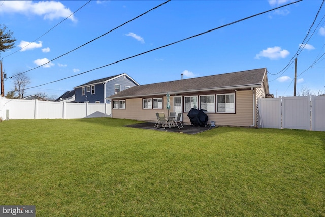 back of house featuring a patio area and a lawn