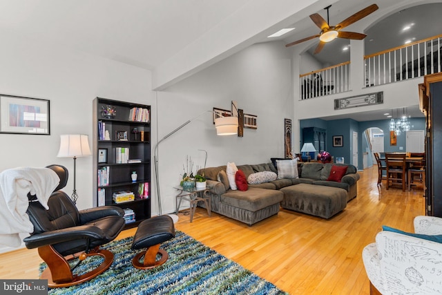 living room with high vaulted ceiling, hardwood / wood-style floors, and ceiling fan