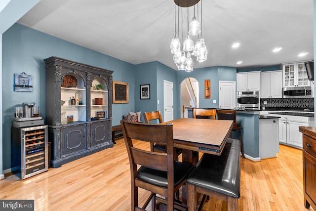 dining space with wine cooler and light hardwood / wood-style floors