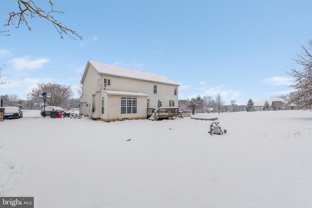 snow covered property with a deck