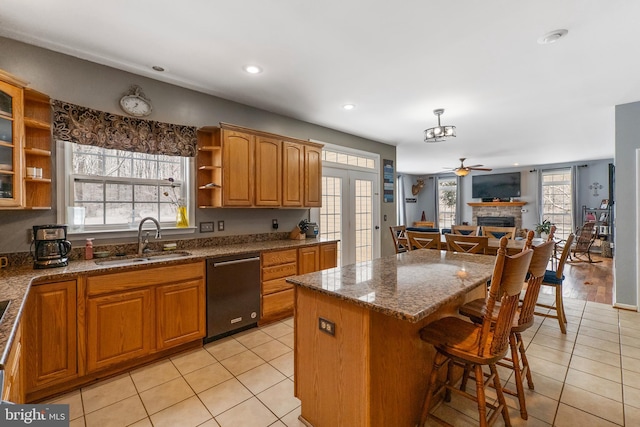 kitchen featuring sink, hanging light fixtures, light tile patterned floors, dishwasher, and a kitchen island