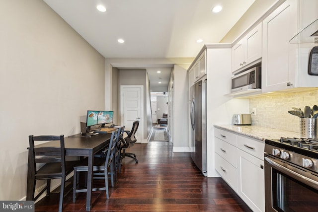 kitchen with white cabinetry, appliances with stainless steel finishes, light stone countertops, dark wood-style floors, and tasteful backsplash