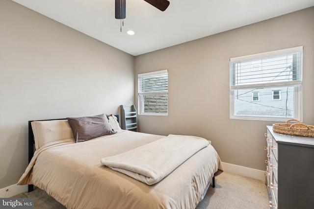 bedroom featuring light colored carpet, ceiling fan, and baseboards