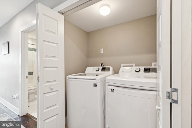 clothes washing area featuring laundry area, baseboards, and independent washer and dryer