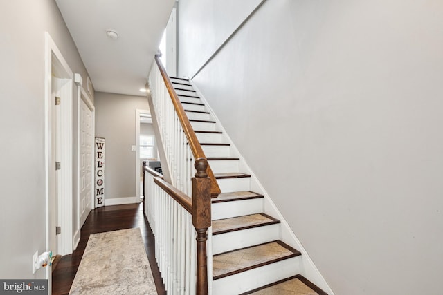 stairs with wood finished floors and baseboards