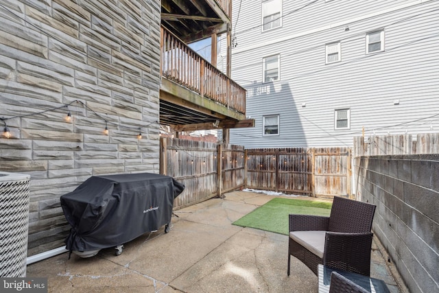 view of patio featuring a fenced backyard, a grill, and central air condition unit