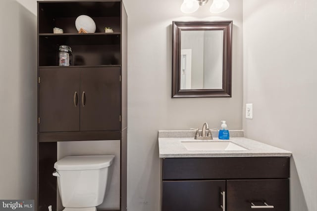 half bath featuring toilet and vanity