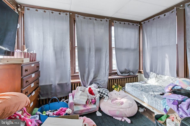 bedroom featuring a drop ceiling and radiator heating unit