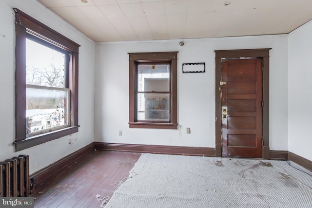 empty room featuring radiator and dark hardwood / wood-style floors