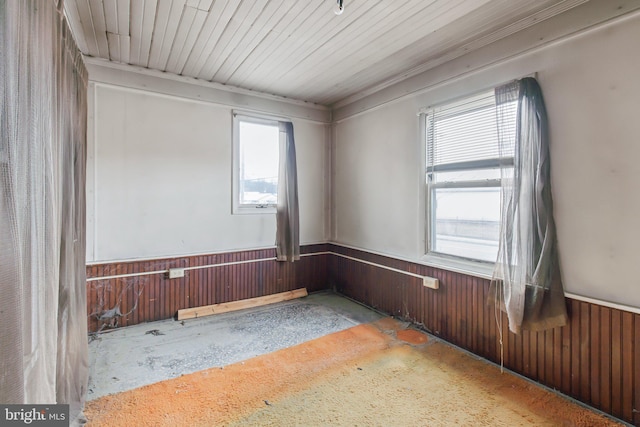 spare room featuring wooden ceiling and wood walls