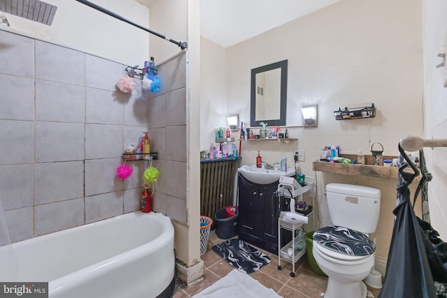 full bathroom featuring tiled shower / bath, tile walls, tile patterned flooring, vanity, and toilet