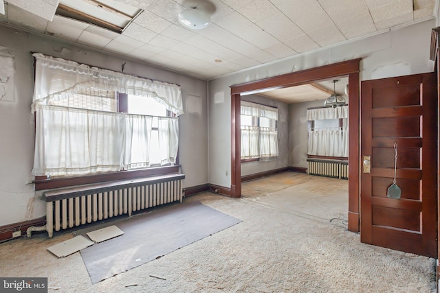 unfurnished room featuring radiator heating unit