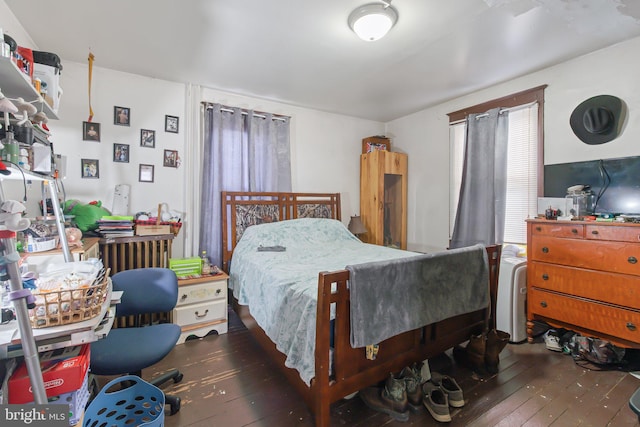 bedroom with radiator and dark wood-type flooring