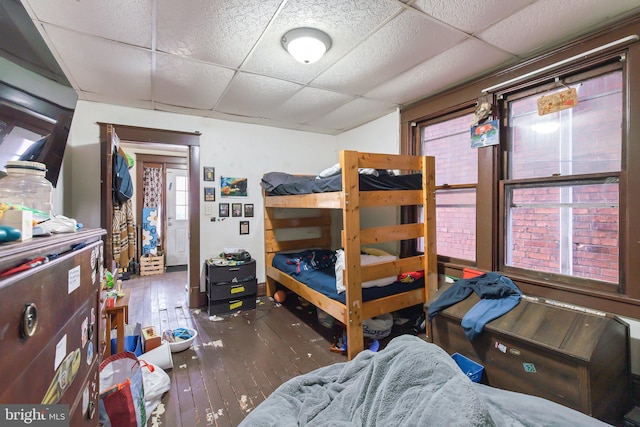 bedroom with a drop ceiling and hardwood / wood-style floors