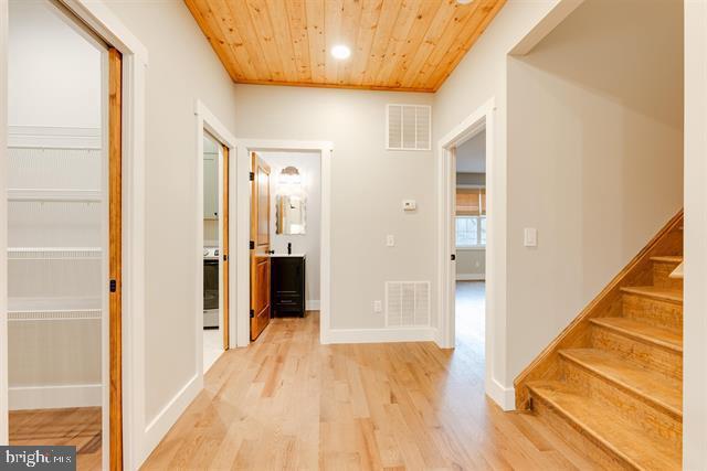 hallway featuring wooden ceiling and light wood-type flooring