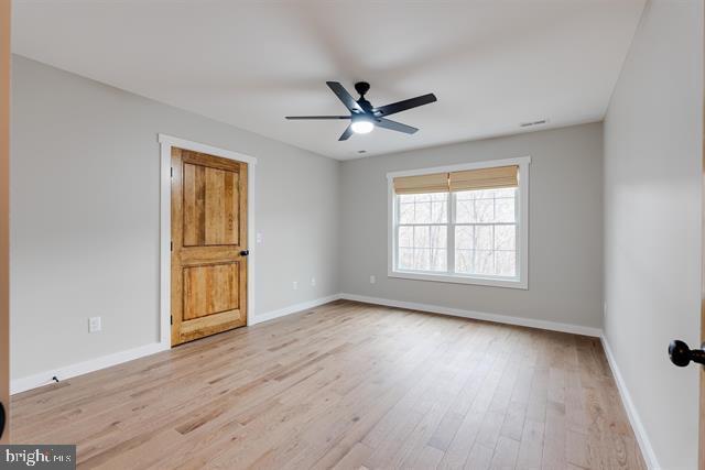 empty room featuring light hardwood / wood-style flooring and ceiling fan