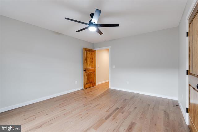 unfurnished bedroom with ceiling fan and light hardwood / wood-style flooring