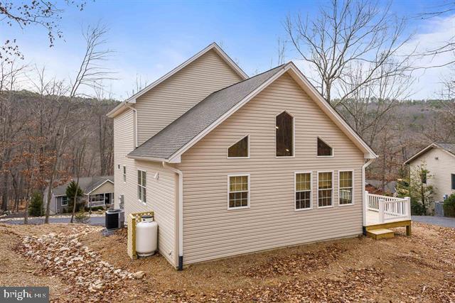 view of side of property featuring central AC unit and a deck