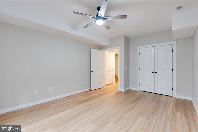 unfurnished bedroom featuring a closet, ceiling fan, and light hardwood / wood-style flooring