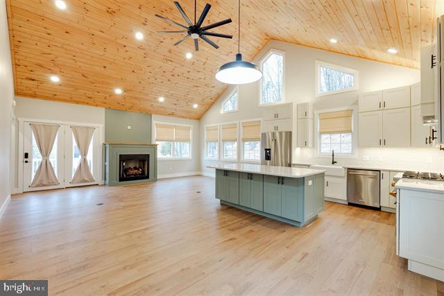 kitchen featuring wood ceiling, appliances with stainless steel finishes, white cabinetry, hanging light fixtures, and a kitchen island