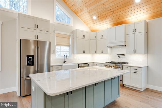 kitchen featuring light stone counters, a center island, and premium appliances