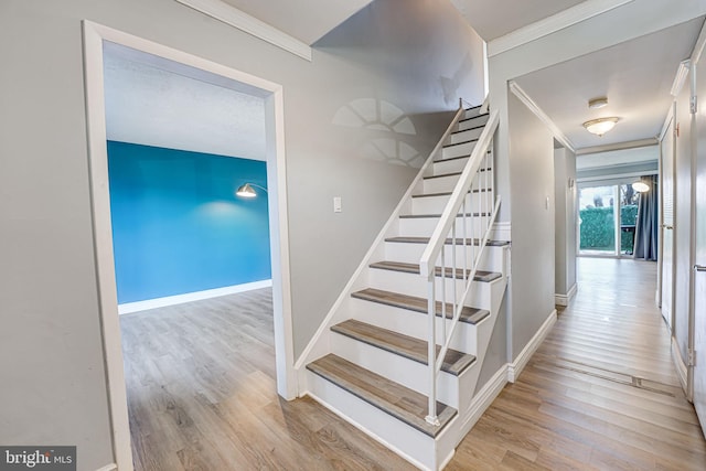 staircase featuring crown molding and hardwood / wood-style floors