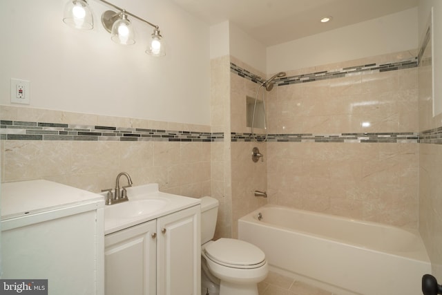 full bathroom with toilet, shower / tub combination, tile patterned flooring, vanity, and tile walls