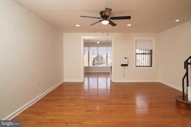 unfurnished living room with light wood finished floors, baseboards, and recessed lighting