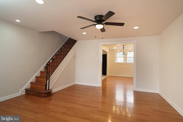 unfurnished living room featuring stairs, baseboards, wood finished floors, and recessed lighting