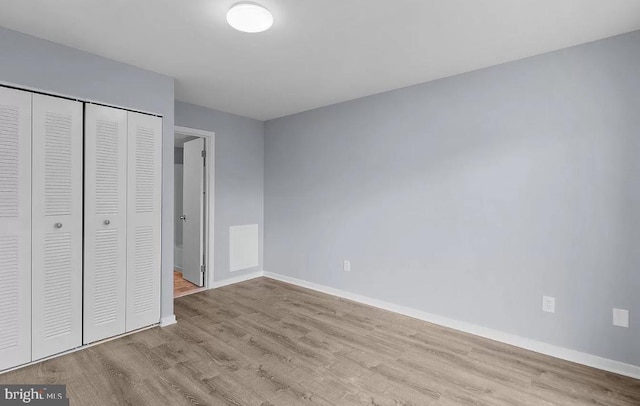 unfurnished bedroom with a closet and light wood-type flooring