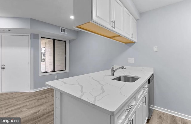 kitchen featuring sink, light hardwood / wood-style flooring, light stone countertops, and white cabinets