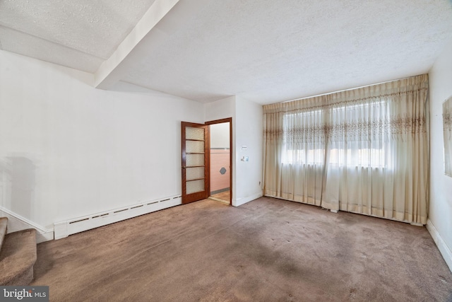 carpeted empty room with a baseboard heating unit and a textured ceiling