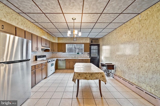 kitchen featuring appliances with stainless steel finishes, light tile patterned floors, baseboard heating, and decorative light fixtures