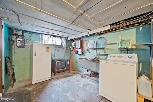 basement featuring refrigerator, washer / dryer, and sink