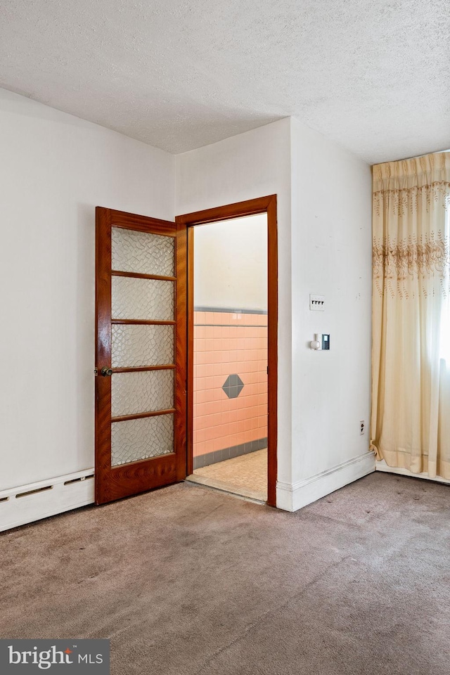 unfurnished room with carpet flooring, a textured ceiling, and baseboard heating