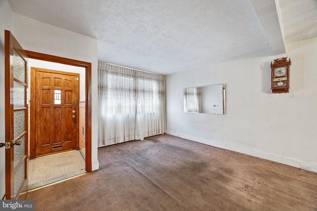 foyer featuring a textured ceiling and carpet flooring