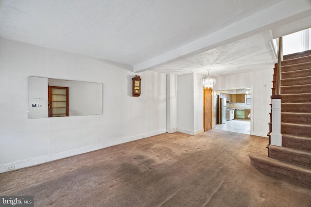 carpeted empty room with an inviting chandelier and a textured ceiling